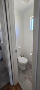 a white bathroom with a toilet and a window at Four Seasons Holiday Park in Marybrook +15 photos