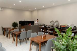 a restaurant with tables and a chef in the kitchen at TQ Luxury Hotel & Apartment in An Khê