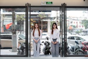 two women standing inside of a revolving door at TQ Luxury Hotel & Apartment in An Khê