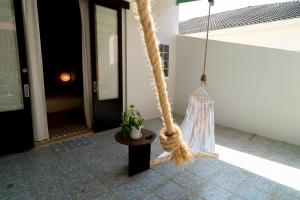 a rope swing with a potted plant on a porch at Oceanchild Khaolak in Khao Lak