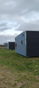 a blue building in the middle of a field at Entre Pinos y Volcanes in Frutillar +11 photos