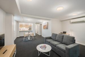 a living room with a couch and a table at Quest Newcastle in Newcastle