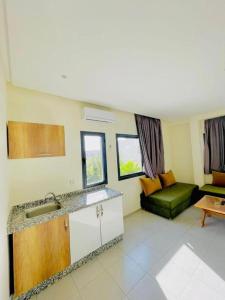 a kitchen with a sink and a couch in a room at Appart Hôtel Pyramides El Jadida in El Jadida +21 photos