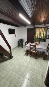 a room with a table and chairs and a television at Los Rochas, Barra de Chuy in Barra del Chuy