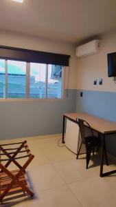 a room with a desk and a table and a chair at Hotel Lagoa in Laguna