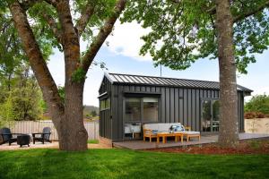 ein kleines schwarzes Containerhaus mit einem Tisch im Hof in der Unterkunft Piccola Blu Tiny House in Hepburn