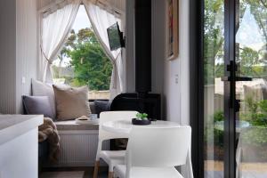 ein Zimmer mit Tisch und Stühlen und einem Fenster in der Unterkunft Piccola Blu Tiny House in Hepburn + 1 Foto