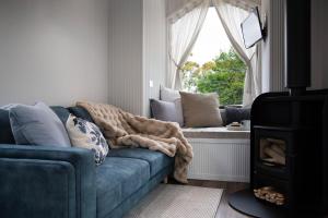 ein Wohnzimmer mit einer blauen Couch und einem Fenster in der Unterkunft Piccola Blu Tiny House in Hepburn