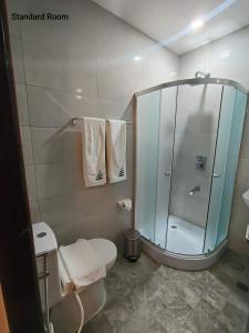 a bathroom with a glass shower and a toilet at RAI ATRIUM SUITES HOTEL - Cauayan in Cauayan City +34 photos