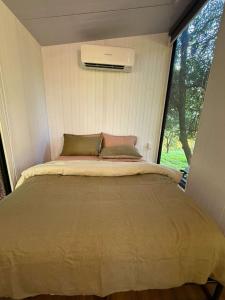 a bed in a small room with a window at Under the Velvet Sky by Tiny Away in Dagun