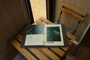a book sitting on top of a wooden table at Under the Velvet Sky by Tiny Away in Dagun