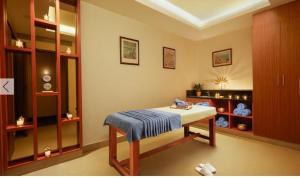 a room with a bed with a blue blanket on it at The Residency Karur in Karūr