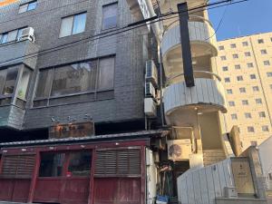 a building with a balcony on the side of it at atic Guesthouse in Takamatsu