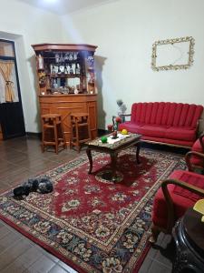 a living room with a red couch and a table at Casa Magnolia in Cochabamba +2 photos