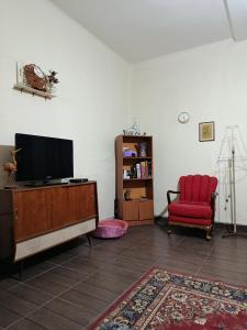 a living room with a tv and a red chair at Casa Magnolia in Cochabamba