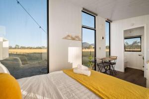 ein Schlafzimmer mit einem Bett und einem großen Fenster in der Unterkunft Billy Button by Tiny Away in Maindample