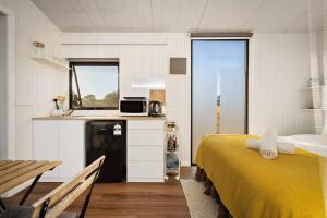 ein Schlafzimmer mit einem gelben Bett und eine Küche in der Unterkunft Billy Button by Tiny Away in Maindample + 10 Fotos