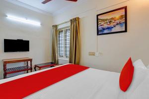 a bedroom with a large bed and a television at Hotel O Le Fort in Trivandrum