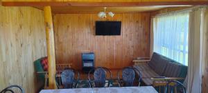 a dining room with a table and chairs and a television at Alojamiento Los Canelos in Ancud