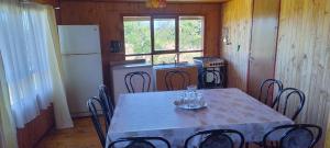 a kitchen with a table with chairs and a refrigerator at Alojamiento Los Canelos in Ancud