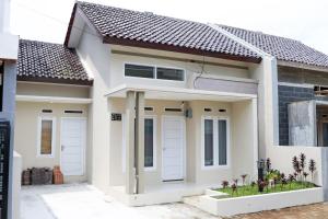a house with two white doors and some plants at SYARIAH - 3BR Homeyy by Sakura in Krawang