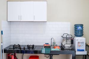 a kitchen with white cabinets and a counter top at SYARIAH - 3BR Homeyy by Sakura in Krawang