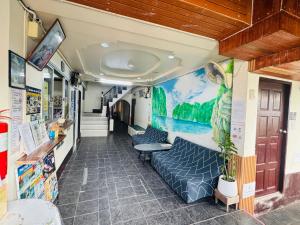 a room with a couch and a painting on the wall at Golden Bee PhiPhi in Phi Phi Islands