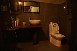 a bathroom with a sink and a toilet and a mirror at H'mong Village Homestay in Sapa