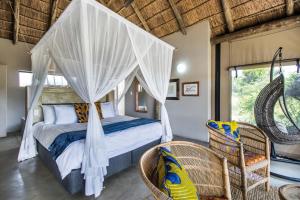 a bedroom with a bed with a mosquito net at LookOut Safari Lodge in Klipdrift +71 photos