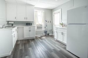 a white kitchen with wooden floors and white cabinets at Cozy Croghan Apartment in Croghan