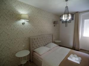 a bedroom with a bed and two tables at Pula Garden Apartments with Shared Pool in Pula