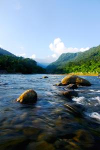 a river with some rocks in the water at Hotel Grand Shah Kamal in Sylhet