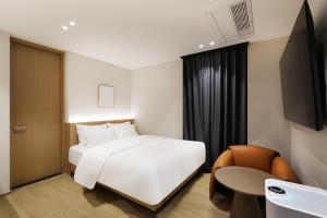 a hotel room with a white bed and a chair at 부천 브라운도트 호텔 부천역점 in Sosa +47 photos