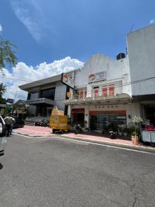 a building with a yellow truck parked in front of it at The Cabin Tugu Hostel in Yogyakarta