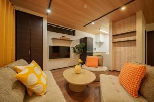 a living room with a couch and a table at LilyHouse in Beppu