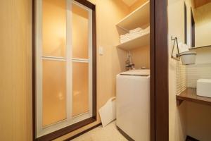 a small bathroom with a toilet and a sink at LilyHouse in Beppu