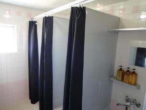 a bathroom with black shower curtains in a bathroom at Pension Orange Box in Miyako Island +28 photos