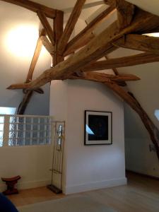 Habitación con vigas a la vista y una foto en la pared. en Les Chambres d'Hôtes du Bois Joli en Semur-en-Auxois