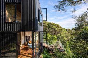 a house with a view of the forest at Blackpool House - Stay Waiheke in Oneroa