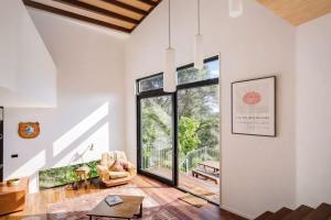 a living room with a large window and a chair at Blackpool House - Stay Waiheke in Oneroa +12 photos