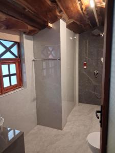 a bathroom with a shower with a sink and a toilet at Sea Shades Cottages with Private Jacuzzi in Palolem +28 photos
