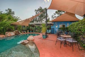 a patio with a table and chairs and a swimming pool at Vatu Sanctuary in Alice Springs