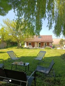 a group of chairs and a table in the grass at Maison Bressanne in Sornay