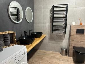 a bathroom with two black sinks and a mirror at Villa Bory in Vygoda +11 photos