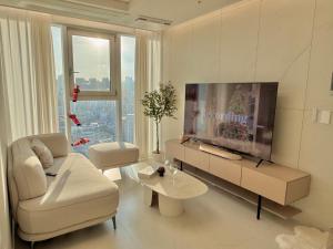 a living room with a tv and a couch and a table at Azur Stay in Kwangan-dong