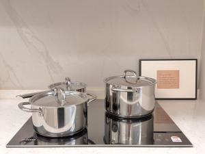 two pots on top of a stove with a picture at Azur Stay in Kwangan-dong