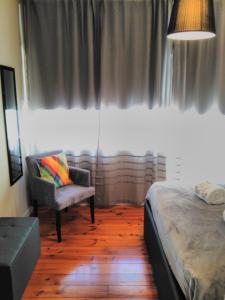 ポルトにあるML Apartments Bolhão Deluxeのベッドルーム1室(ベッド1台、椅子、窓付)
