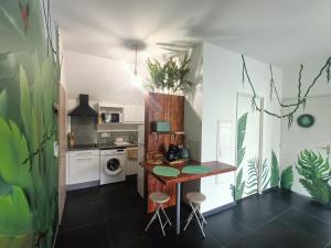 a kitchen with a table and stools in a room at La Cabane du lagon atypique et accès à la plage in La Saline les Bains