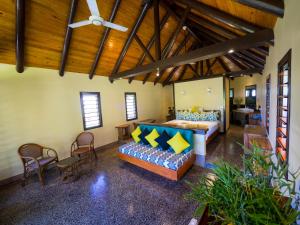 Taveuni Dive Resort في Waiyevo: غرفة نوم بسرير واريكة في غرفة