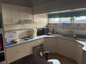 a kitchen with white cabinets and a stove top oven at Dalby home in Dalby